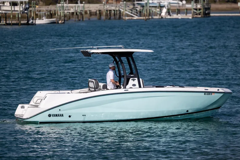 Slide: The Image of 2023 Yamaha Boats 255 FSH Sport E cruising on blue water. - 3
