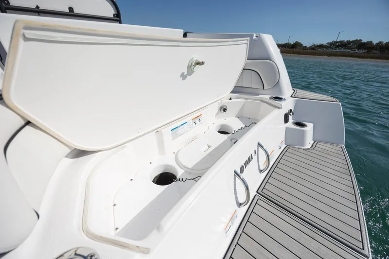 Slide: The Image of 2023 Yamaha Boats 255 FSH Sport E, open storage compartment, sleek deck design. - 31