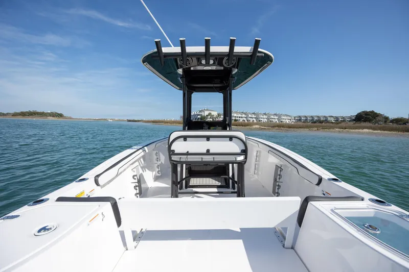 Slide: The Image of 2023 Yamaha Boats 255 FSH Sport E on calm water, showcasing sleek design and spacious deck. - 32