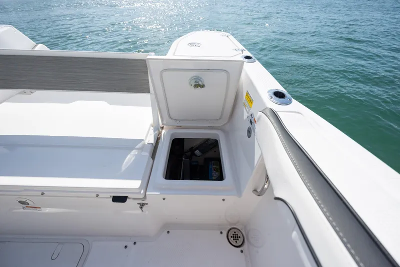 Slide: The Image of 2023 Yamaha Boats 255 FSH Sport E, open storage compartment, on calm water. - 36