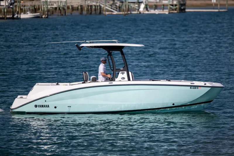 Slide: The Image of 2023 Yamaha Boats 255 FSH Sport E cruising on blue water. - 4