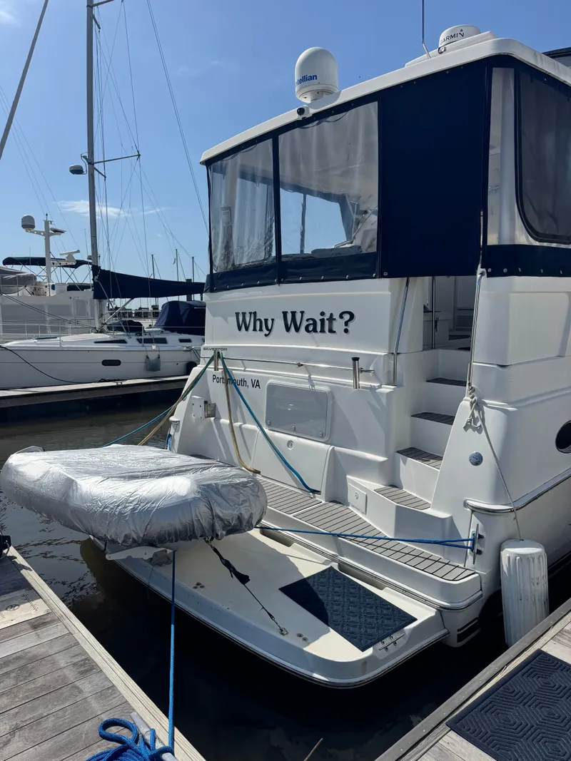 Slide: The Image of 2000 Silverton 392 Motor Yacht docked, featuring "Why Wait?" signage. - 2