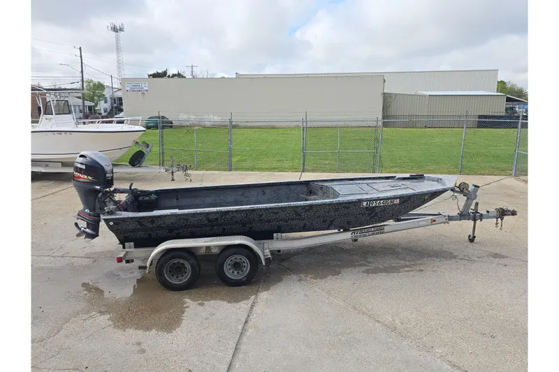 The Image of Custom Rene Gros 2022 boat on trailer, parked in industrial area with overcast sky. - 0