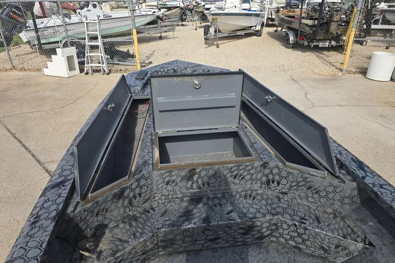 Slide: The Image of Open storage compartments on a 2022 Custom Rene Gros boat, parked in a marina. - 10