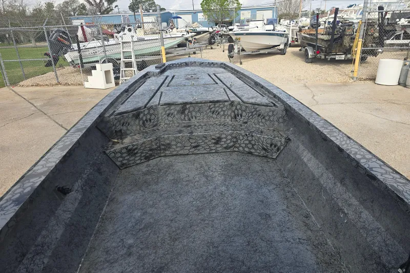 Slide: The Image of Custom 2022 Rene Gros boat interior with textured flooring, parked in a boatyard. - 12