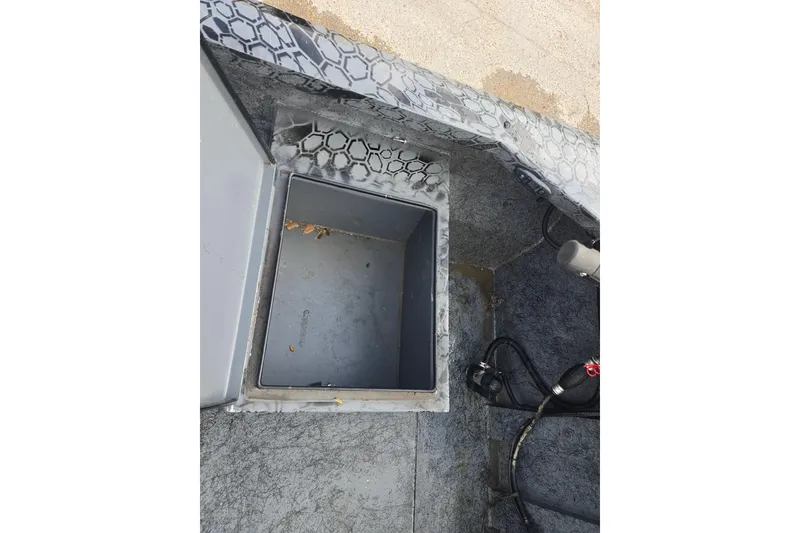 Slide: The Image of Open storage compartment in a 2022 Custom Rene Gros boat with hexagonal pattern design. - 14