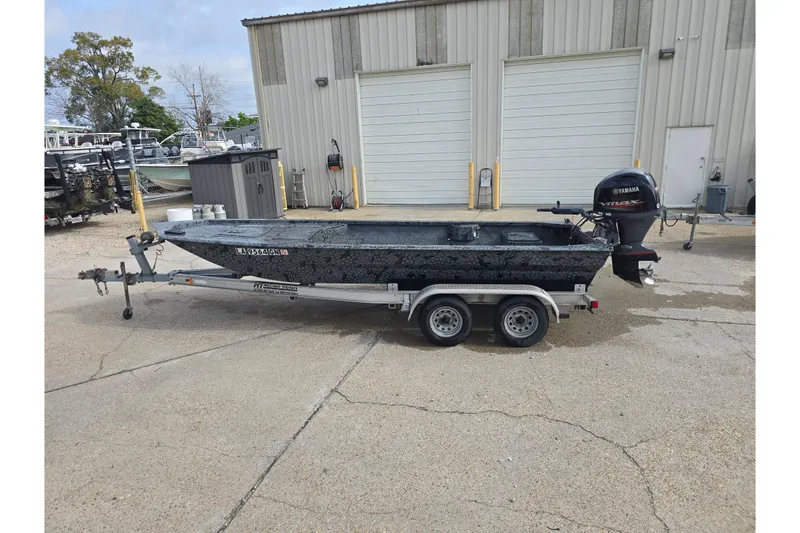 Slide: The Image of Custom 2022 Rene Gros boat on trailer with Yamaha outboard motor, parked outside a warehouse. - 5