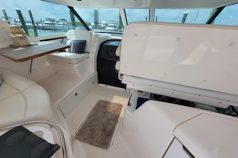 Slide: The Image of Interior of 2005 Tiara Yachts 4400 Sovran, featuring white seating and a wooden table. - 10