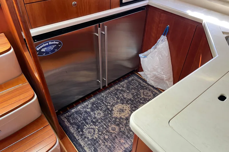 Slide: The Image of 2005 Tiara Yachts 4400 Sovran interior with stainless steel fridge and wooden cabinetry. - 12