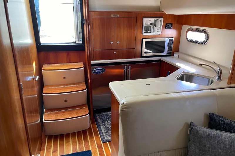 Slide: The Image of 2005 Tiara Yachts 4400 Sovran interior with kitchen, stairs, and wooden cabinetry. - 19