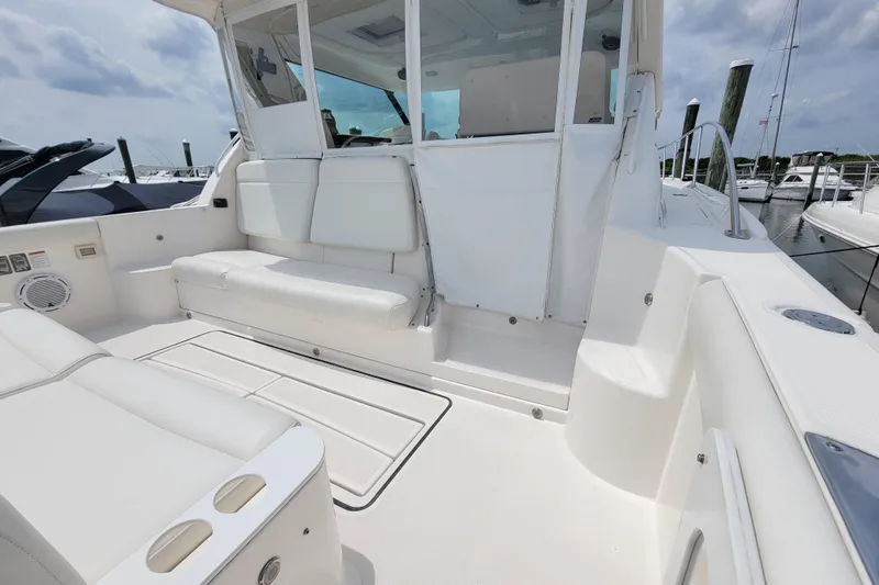 Slide: The Image of 2005 Tiara Yachts 4400 Sovran cockpit with white seating and marina view. - 3