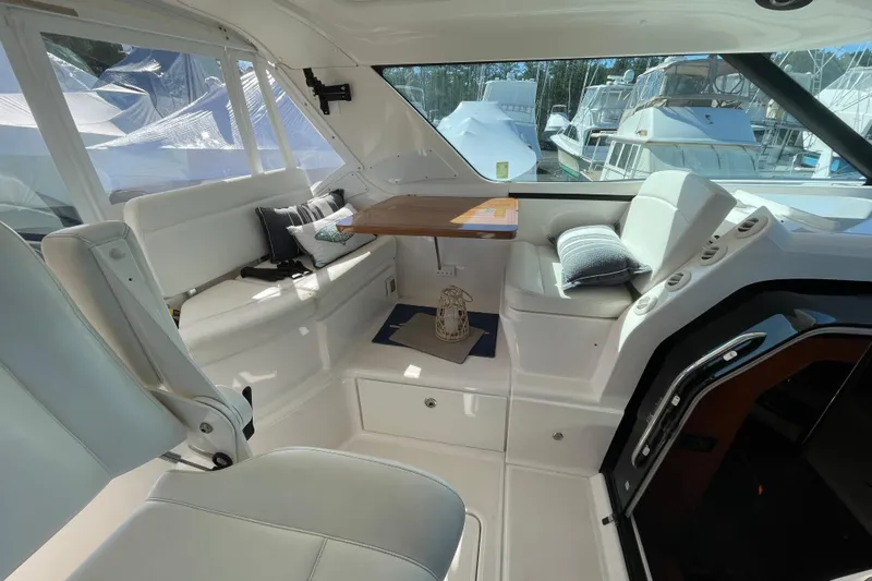 Slide: The Image of Interior of 2005 Tiara Yachts 4400 Sovran, featuring white seating and a wooden table. - 9