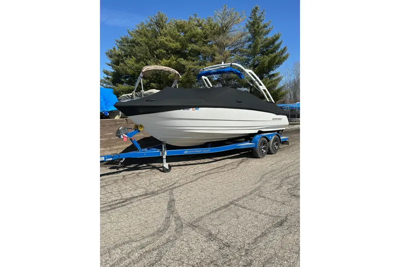 Slide: The Image of 2018 Monterey 224FS boat on trailer, covered, parked outdoors with trees in background. - 17