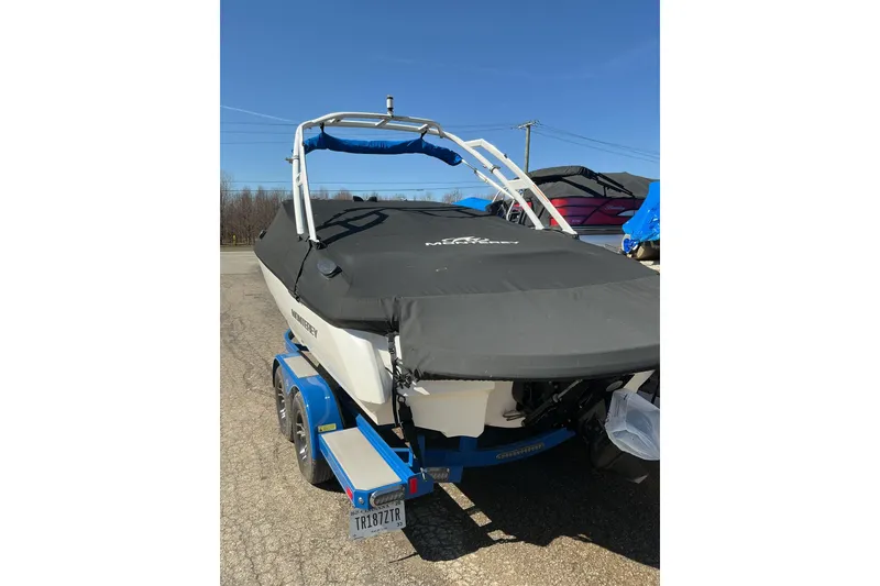 Slide: The Image of 2018 Monterey 224FS boat on trailer, covered, parked outdoors under clear sky. - 18