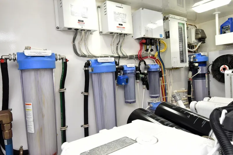 Slide: The Image of Engine room of 2019 Viking 80 Sky Bridge yacht with filtration systems and wiring. - 120