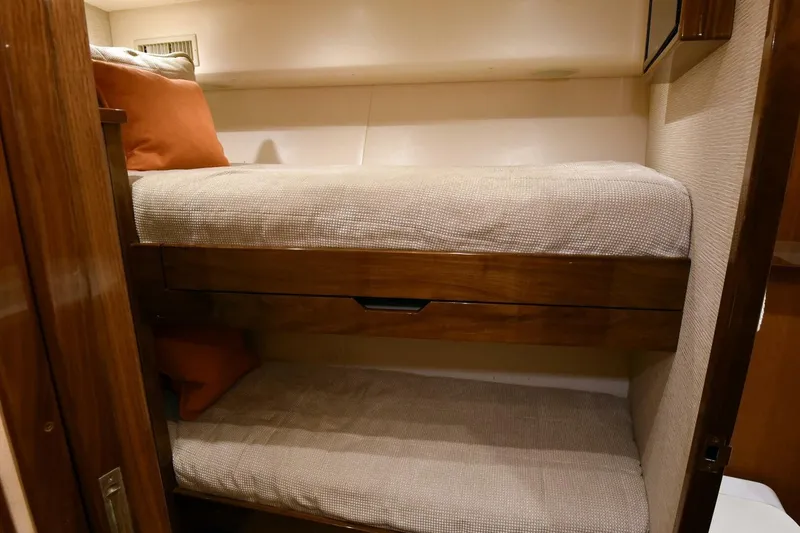 Slide: The Image of 2019 Viking 80 Sky Bridge yacht interior with cozy bunk beds and wooden accents. - 30