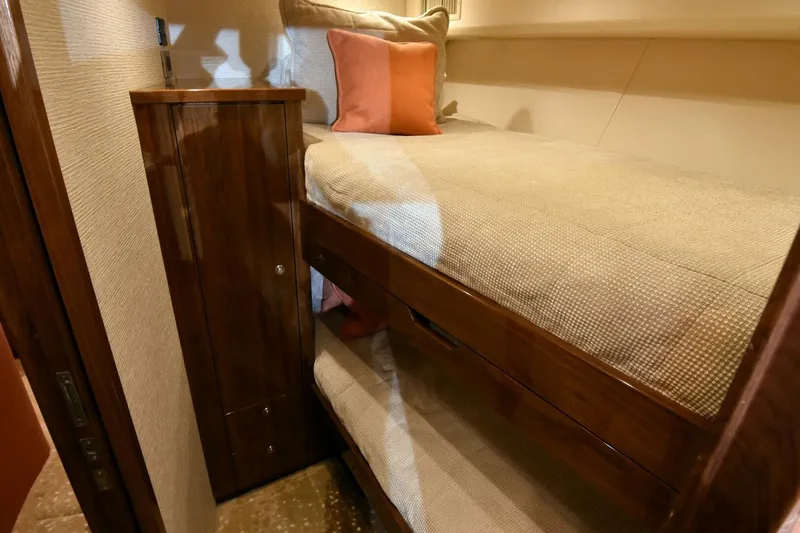 Slide: The Image of 2019 Viking 80 Sky Bridge yacht interior with cozy bunk beds and wooden cabinetry. - 31