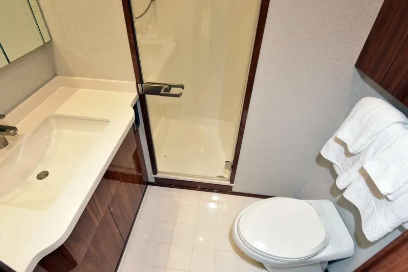 Slide: The Image of Luxurious bathroom in 2019 Viking 80 Sky Bridge yacht with shower, sink, and toilet. - 39