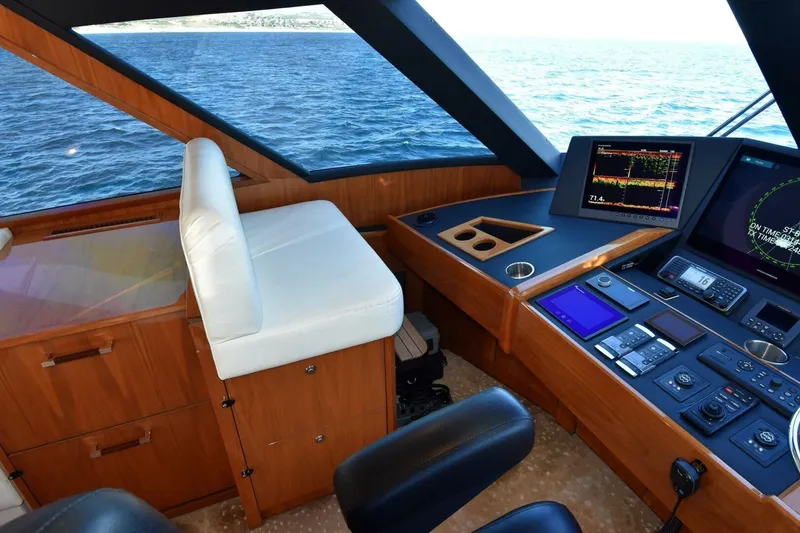 Slide: The Image of Interior helm of 2019 Viking 80 Sky Bridge yacht with navigation controls and ocean view. - 57