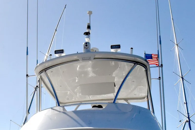 Slide: The Image of 2019 Viking 80 Sky Bridge yacht with American flag and antennas against blue sky. - 79