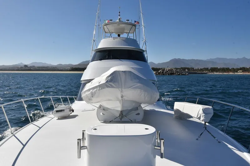 Slide: The Image of 2019 Viking 80 Sky Bridge yacht cruising on open water with scenic coastline. - 85