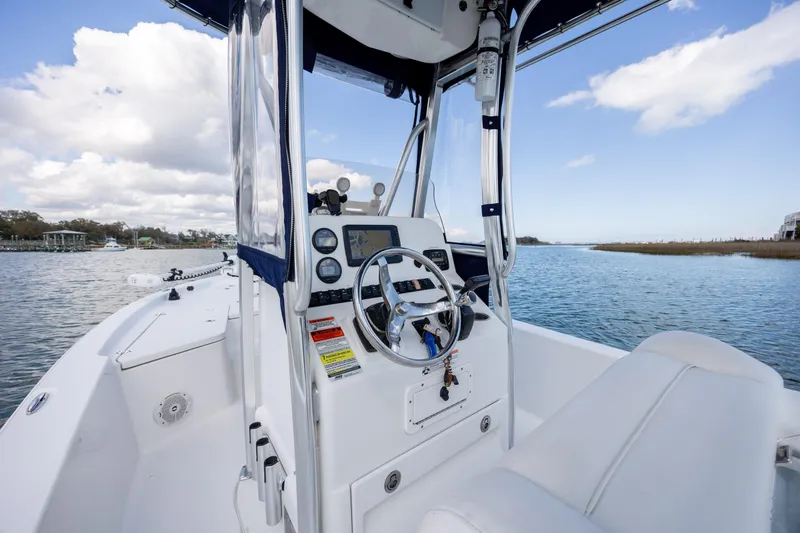 Slide: The Image of 2015 Sea Hunt BX 22 Pro boat interior with steering wheel, on calm water. - 8