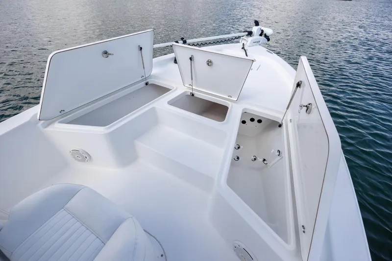 Slide: The Image of 2015 Sea Hunt BX 22 Pro boat with open storage compartments on calm water. - 9