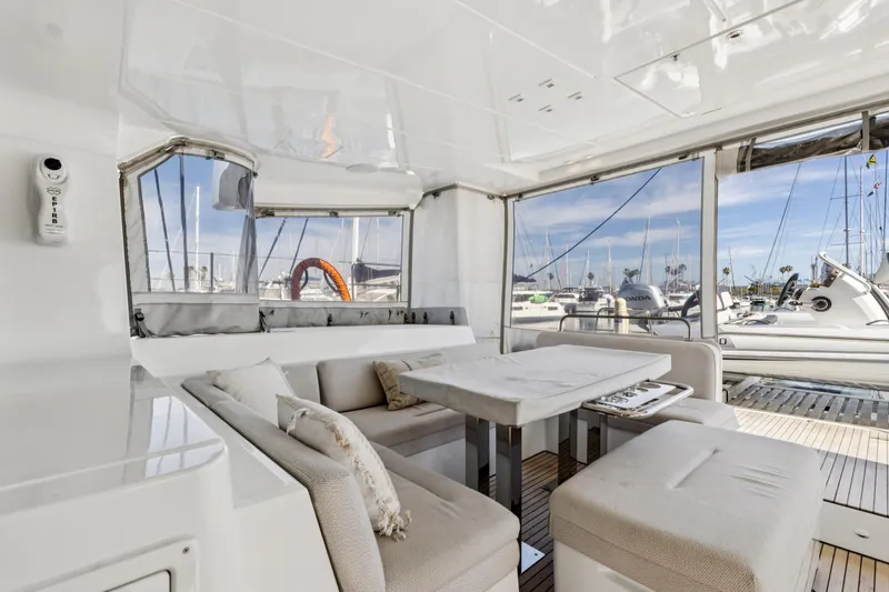 Slide: The Image of Luxurious 2022 Lagoon 52 F yacht interior with elegant seating and marina view. - 23