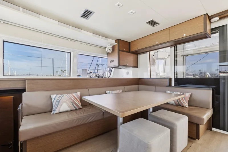 Slide: The Image of Interior of 2022 Lagoon 52 F yacht with modern dining area and large windows. - 29