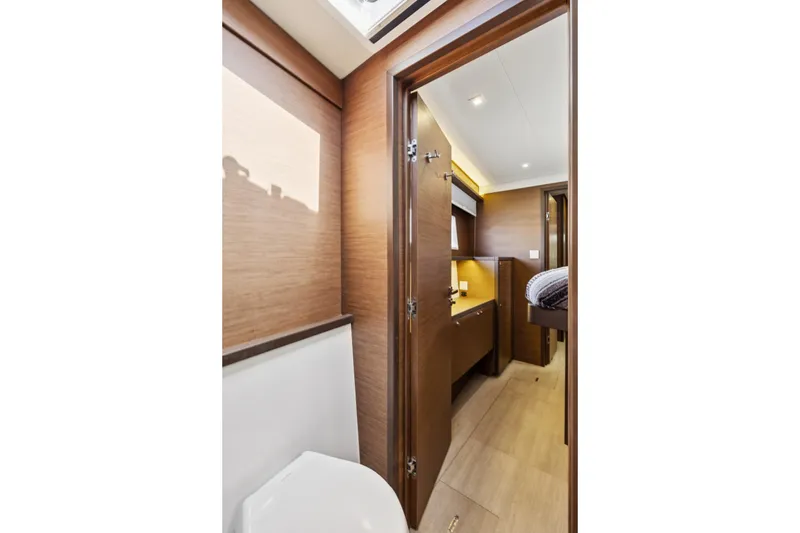Slide: The Image of Interior of 2022 Lagoon 52 F yacht, featuring modern wood finishes and cozy cabin space. - 41