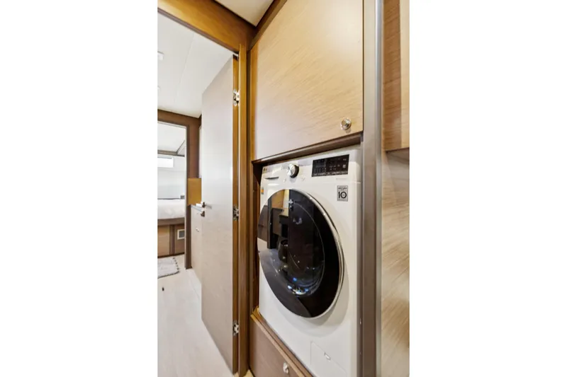 Slide: The Image of Laundry area inside 2022 Lagoon 52 F yacht, featuring a modern washing machine. - 49