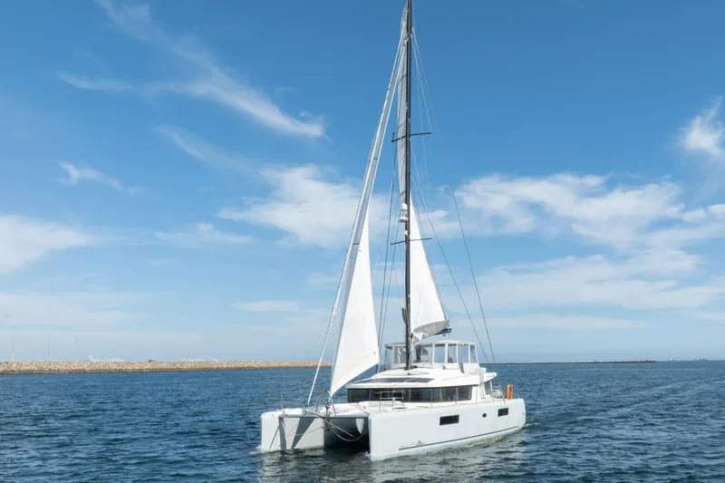 Slide: The Image of 2022 Lagoon 52 F catamaran sailing on a clear blue sea under a sunny sky. - 5