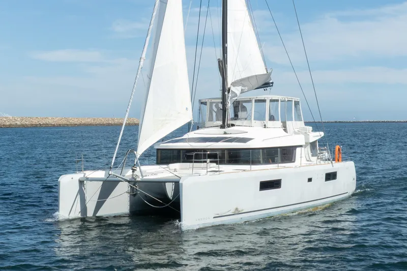 Slide: The Image of 2022 Lagoon 52 F catamaran sailing on open water under clear skies. - 6