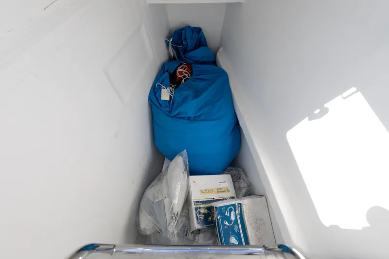 Slide: The Image of Storage compartment on 2022 Lagoon 52 F yacht with blue bag and boxes. - 62