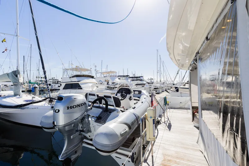 Slide: The Image of 2022 Lagoon 52 F yacht docked with inflatable boat and Honda motor. - 65