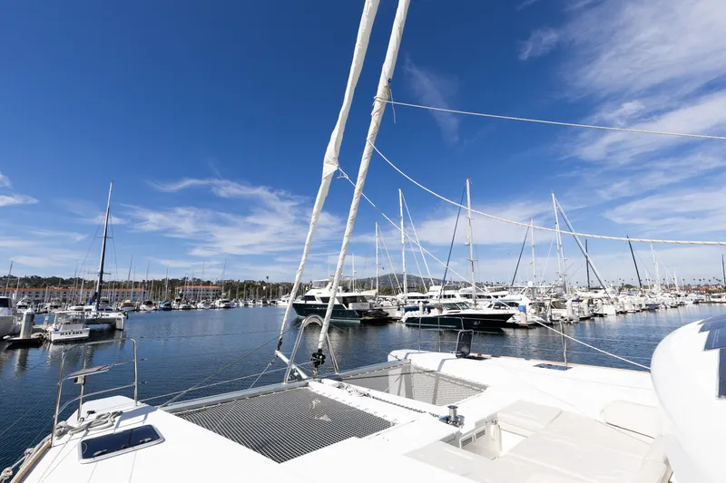 Slide: The Image of 2022 Lagoon 52 F catamaran docked in a sunny marina with clear blue skies. - 80