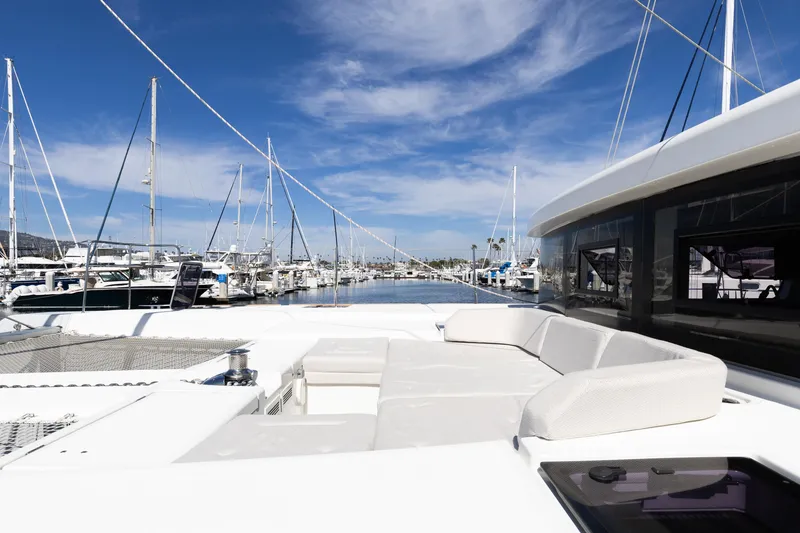 Slide: The Image of 2022 Lagoon 52 F catamaran docked at marina under clear blue sky. - 81