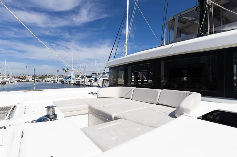 Slide: The Image of Luxurious 2022 Lagoon 52 F yacht with spacious deck seating in a marina setting. - 82