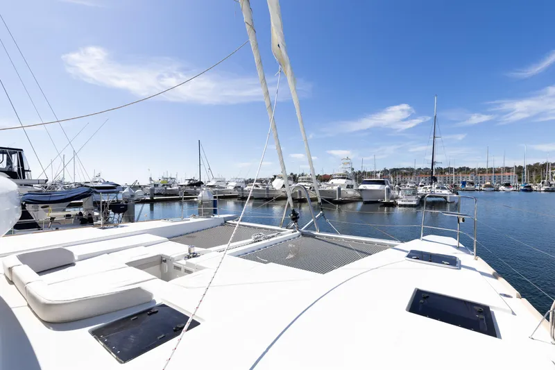 Slide: The Image of 2022 Lagoon 52 F catamaran docked in a sunny marina with clear blue skies. - 83