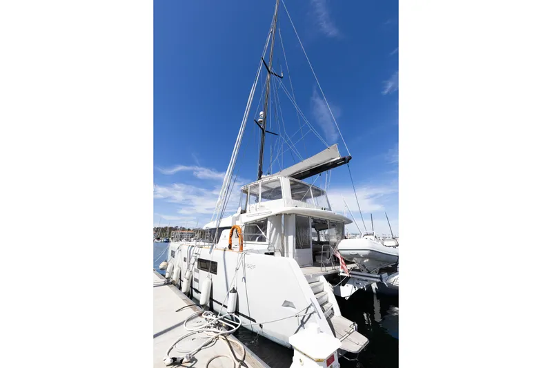Slide: The Image of 2022 Lagoon 52 F catamaran docked at marina under clear blue sky. - 85