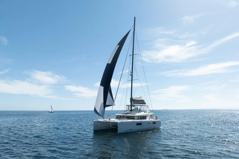 Slide: The Image of 2022 Lagoon 52 F catamaran sailing on a sunny day with clear blue skies. - 92