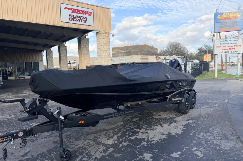 Slide: The Image of 2026 Vexus VXs21 boat covered on trailer at dealership parking lot. - 3