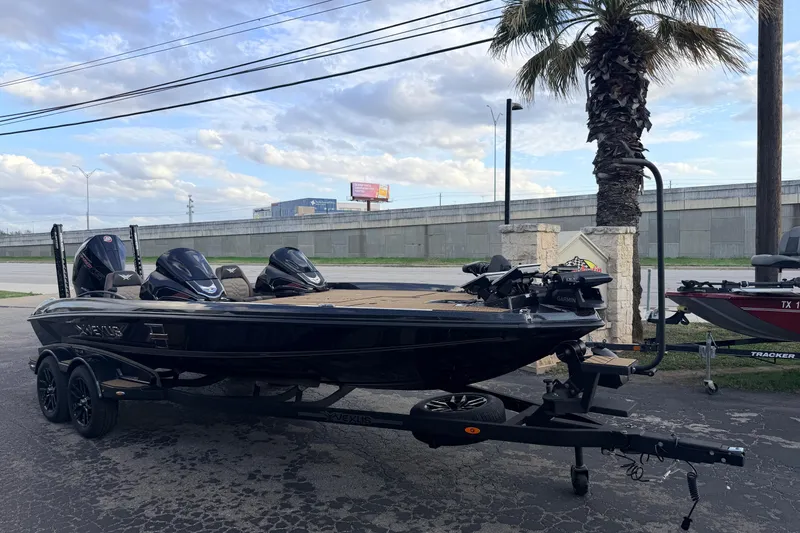 Slide: The Image of 2026 Vexus VXs21 boat on trailer, parked near palm tree under cloudy sky. - 7