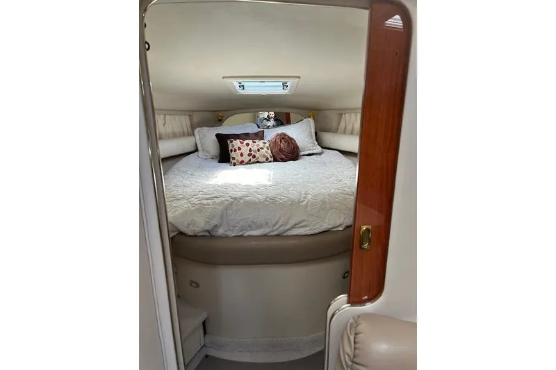 Slide: The Image of 1998 Sea Ray Sundancer 370 cabin interior with cozy bed and decorative pillows. - 10