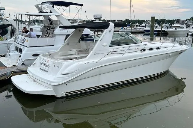 Slide: The Image of 1998 Sea Ray Sundancer 370 yacht docked in a marina, featuring sleek white design. - 3