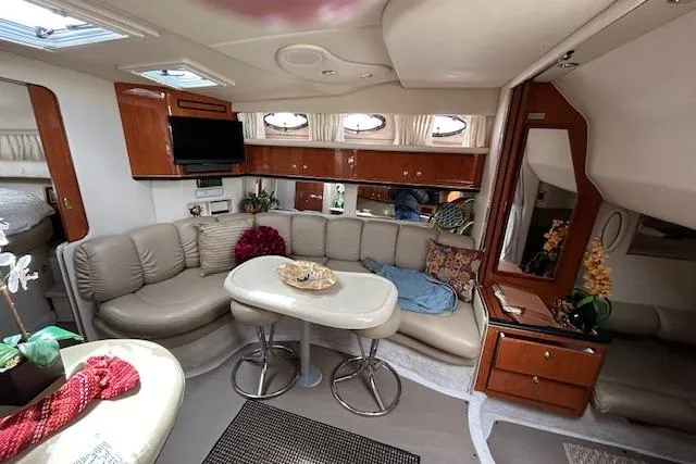 Slide: The Image of 1998 Sea Ray Sundancer 370 interior with cozy seating, table, and elegant wood cabinetry. - 9