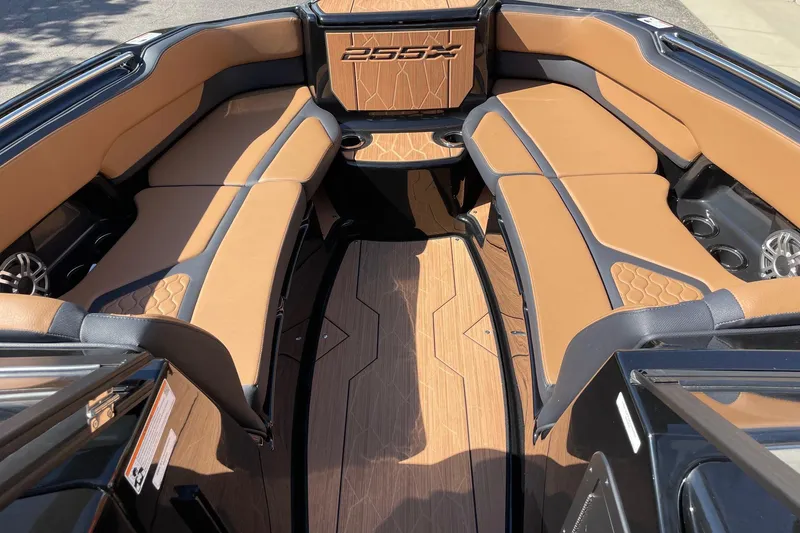 Slide: The Image of 2026 Yamaha Boats 255XD interior with tan and black seating, modern design, and cup holders. - 11