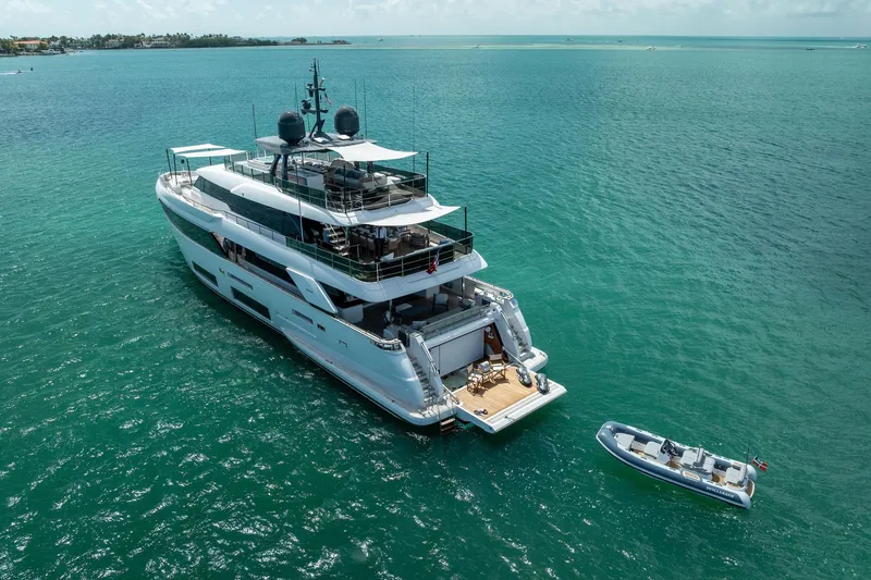 Slide: The Image of Luxurious 2023 Custom Line Navetta 33 yacht cruising on turquoise waters under a clear sky. - 160