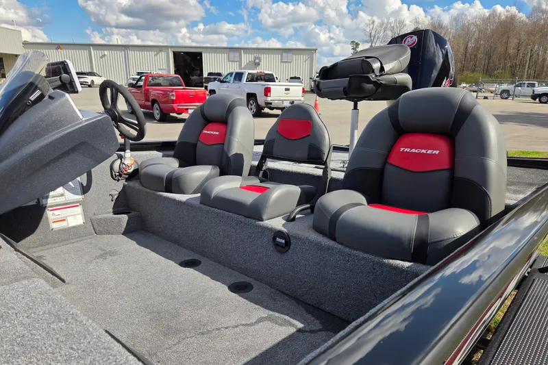 Slide: The Image of 2025 Tracker Savage 215 boat interior with gray and red seating, steering wheel, and console. - 11