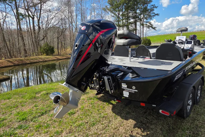 Slide: The Image of 2025 Tracker Savage 215 boat with powerful outboard motor by a scenic lake. - 3